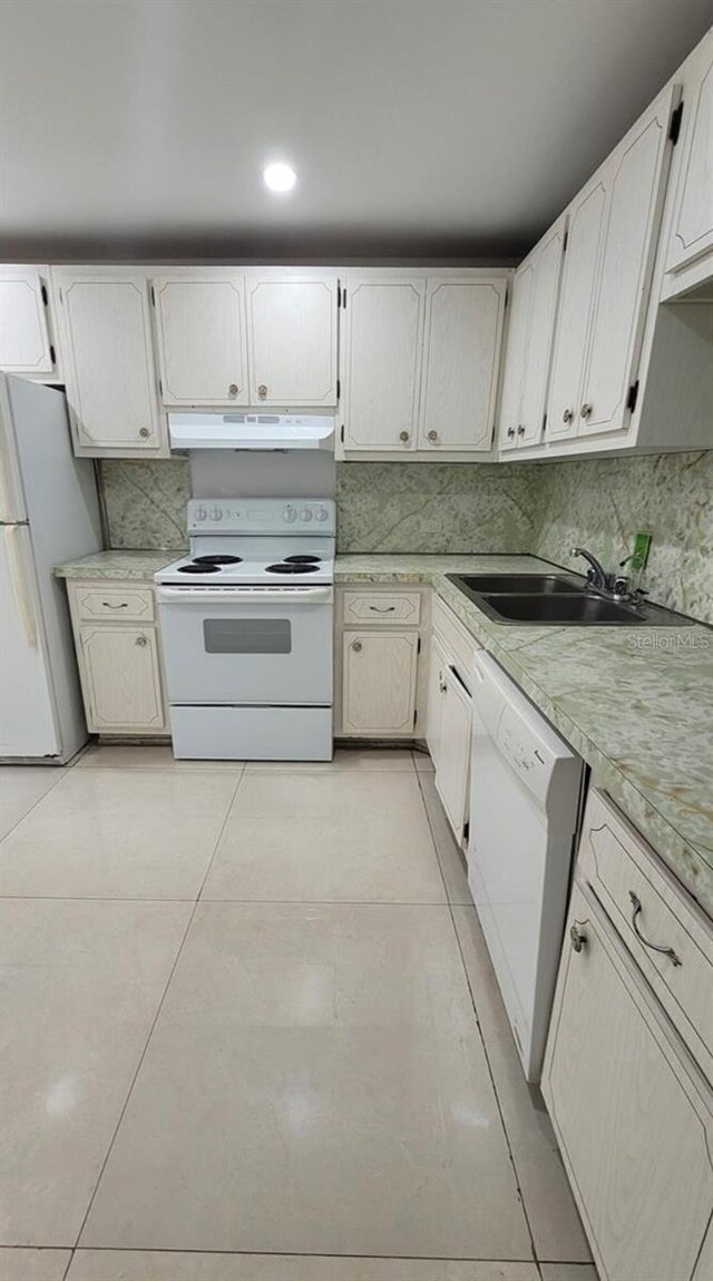 kitchen featuring white cabinets, light tile patterned floors, white appliances, and sink