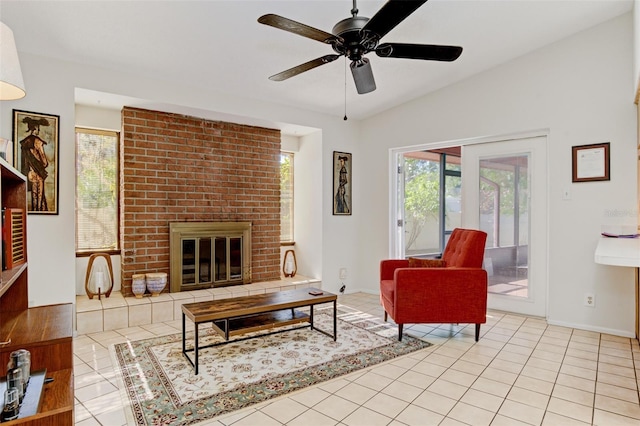 living room featuring a brick fireplace, light tile patterned floors, vaulted ceiling, and ceiling fan