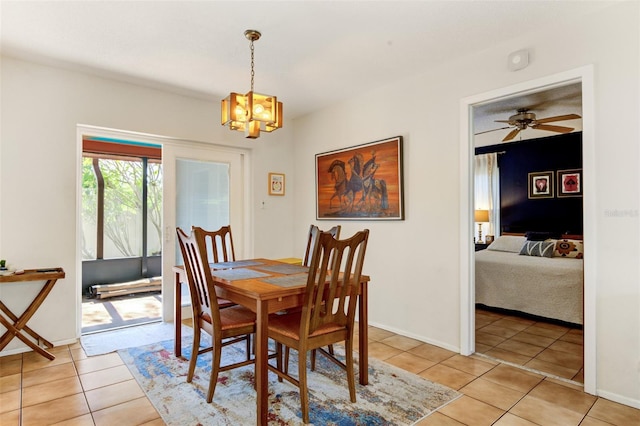 tiled dining space with ceiling fan with notable chandelier