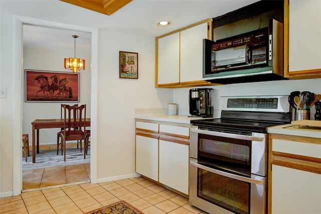 kitchen with stainless steel electric stove, white cabinets, light tile patterned flooring, and decorative light fixtures