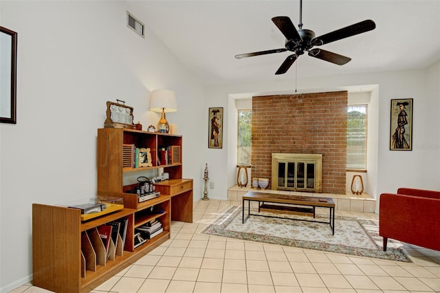 tiled living room with ceiling fan and a brick fireplace