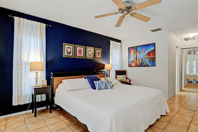 bedroom featuring multiple windows, ceiling fan, and light tile patterned flooring