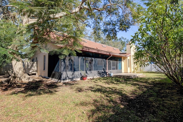 back of house with a sunroom and a yard