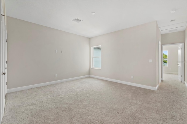 unfurnished room with a wealth of natural light and light carpet