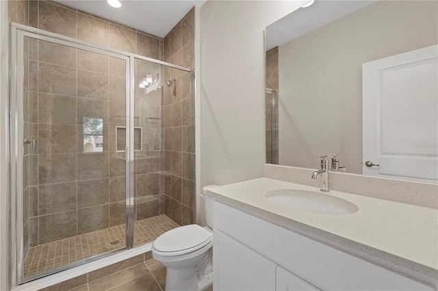 bathroom with toilet, vanity, tile patterned floors, and an enclosed shower