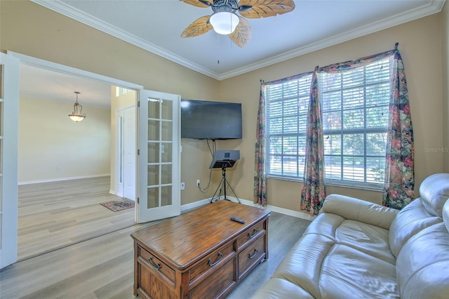 living room with crown molding, a wealth of natural light, and light hardwood / wood-style flooring