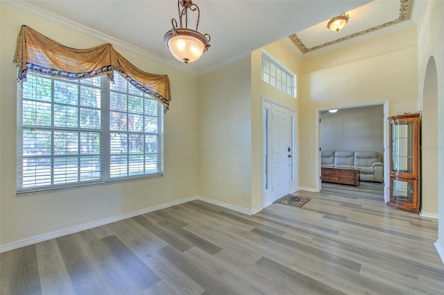 entrance foyer with light hardwood / wood-style floors and crown molding