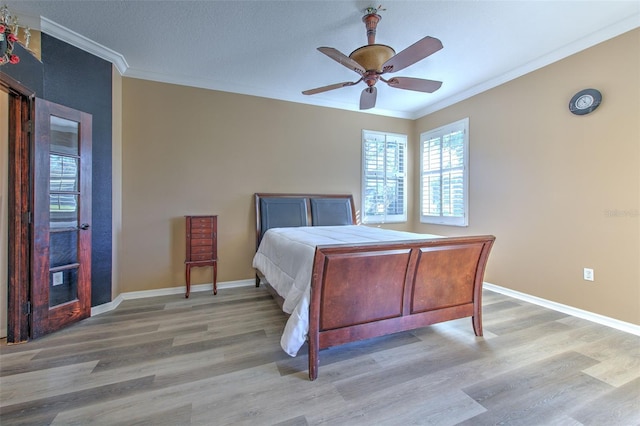 bedroom with ceiling fan, light wood-type flooring, and crown molding