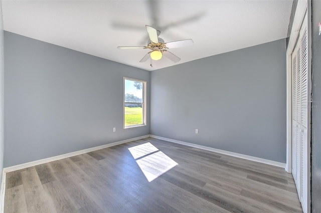 unfurnished bedroom featuring ceiling fan, a closet, and hardwood / wood-style flooring