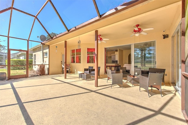 view of patio featuring outdoor lounge area, ceiling fan, and glass enclosure