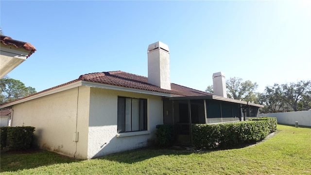 back of house featuring a sunroom and a yard