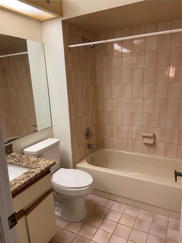 full bathroom featuring tile patterned floors, vanity, toilet, and tiled shower / bath combo