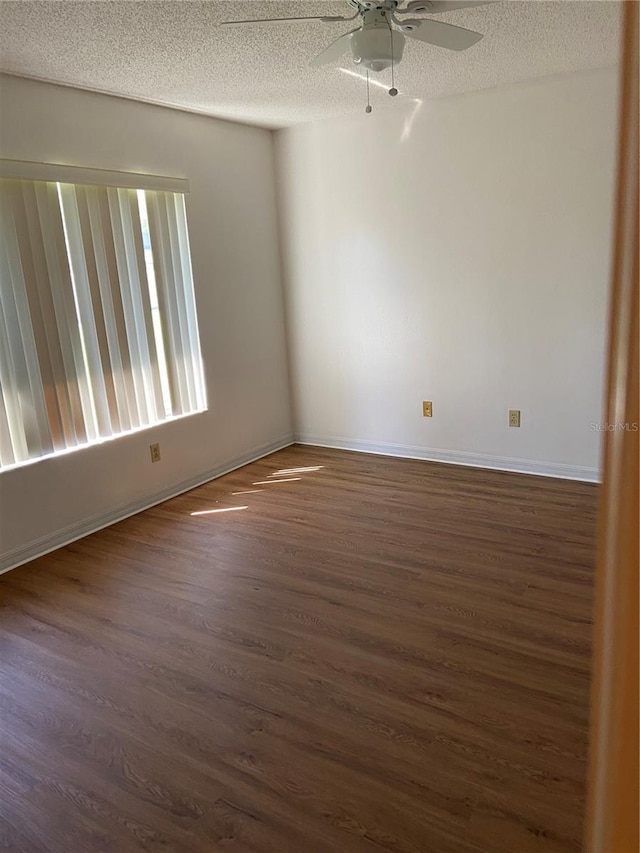 unfurnished room with a textured ceiling, ceiling fan, and dark wood-type flooring