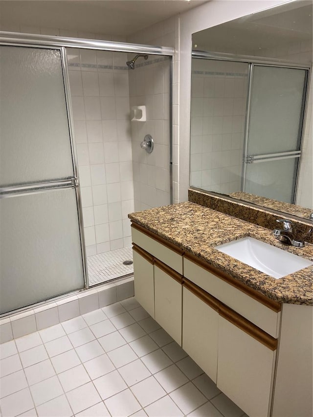 bathroom with tile patterned flooring, vanity, and an enclosed shower