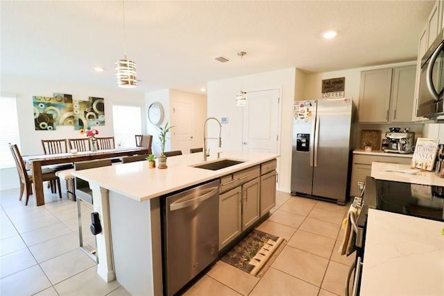 kitchen with sink, a center island with sink, decorative light fixtures, and appliances with stainless steel finishes