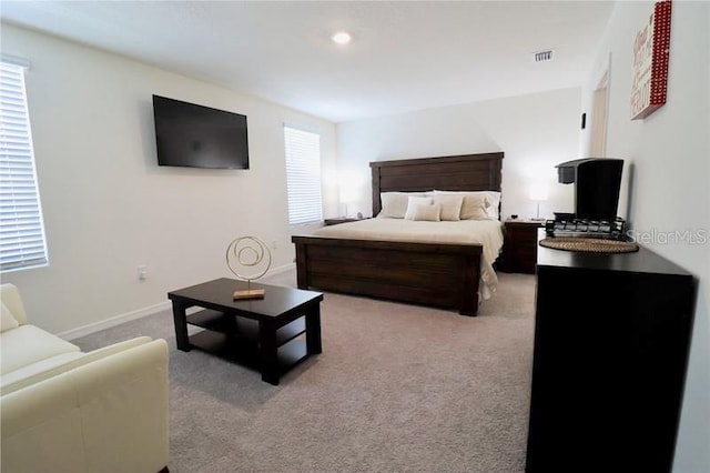 bedroom with multiple windows and light colored carpet