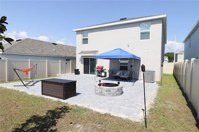 back of property with an outdoor living space with a fire pit, a patio area, and a lawn