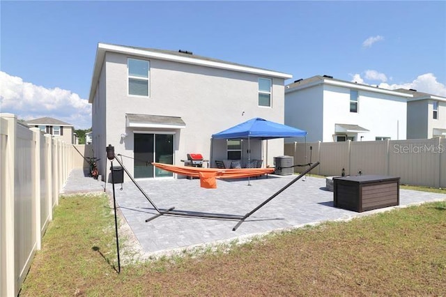 rear view of property with a lawn and a patio