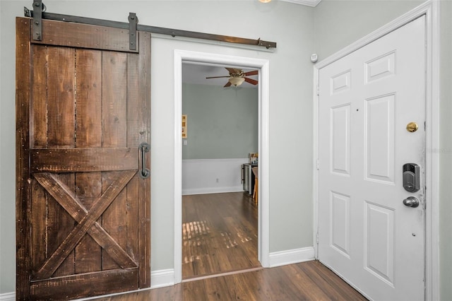 foyer featuring dark hardwood / wood-style flooring, a barn door, and ceiling fan