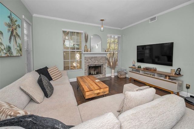 living room featuring a wealth of natural light, hardwood / wood-style floors, crown molding, and a brick fireplace