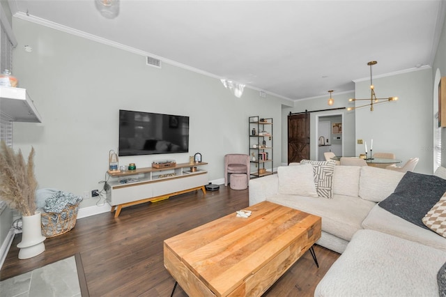 living room with a barn door, crown molding, dark hardwood / wood-style flooring, and a notable chandelier