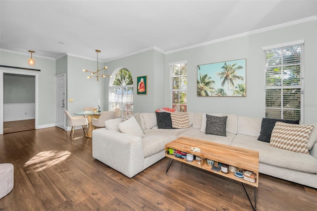 living room with crown molding, hardwood / wood-style floors, and an inviting chandelier