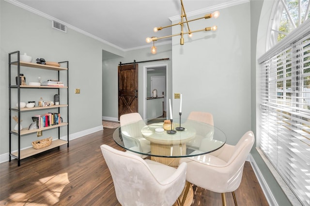 dining space with a barn door, dark hardwood / wood-style flooring, a chandelier, and ornamental molding