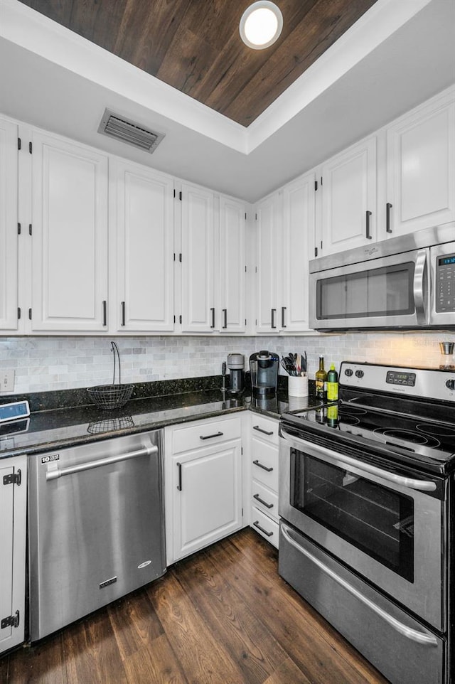 kitchen featuring stainless steel appliances, white cabinetry, tasteful backsplash, and dark wood-type flooring