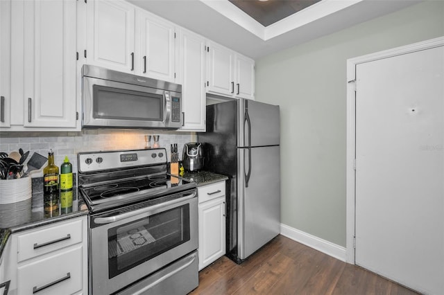 kitchen with decorative backsplash, white cabinetry, and appliances with stainless steel finishes