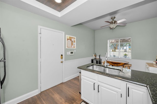 kitchen featuring white cabinetry, sink, dark stone counters, and dark hardwood / wood-style floors