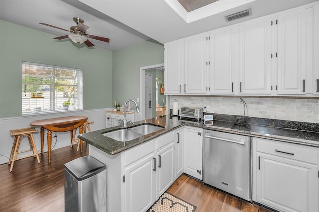 kitchen with white cabinetry, sink, dark wood-type flooring, stainless steel dishwasher, and kitchen peninsula