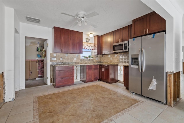 kitchen featuring backsplash, ceiling fan, a textured ceiling, appliances with stainless steel finishes, and light tile patterned flooring