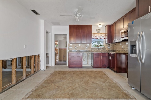 kitchen with ceiling fan, light stone countertops, light tile patterned floors, tasteful backsplash, and stainless steel appliances