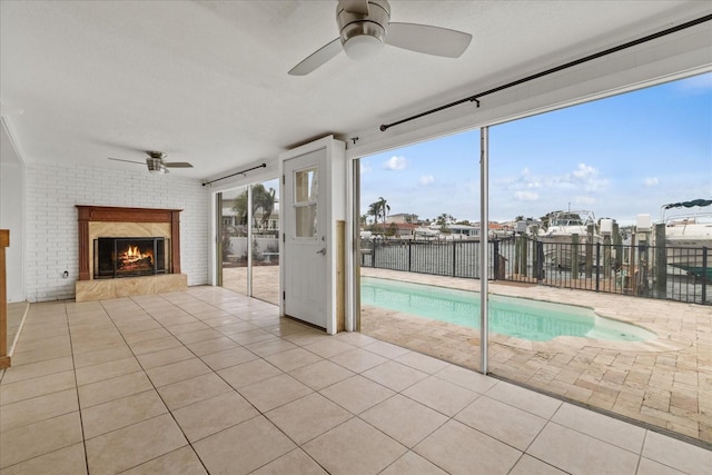 view of pool with ceiling fan and a water view