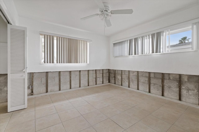 spare room with ceiling fan and light tile patterned flooring