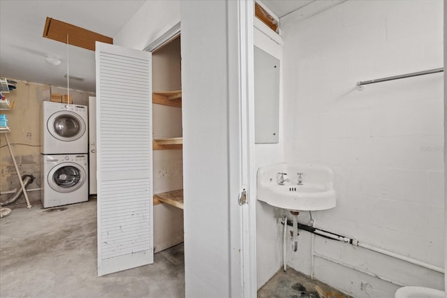 clothes washing area featuring stacked washing maching and dryer