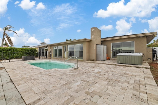 exterior space featuring a swimming pool with hot tub and a patio