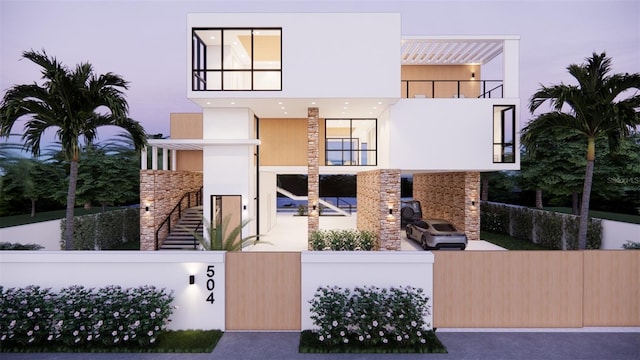 contemporary home with stairway, a fenced front yard, and stucco siding