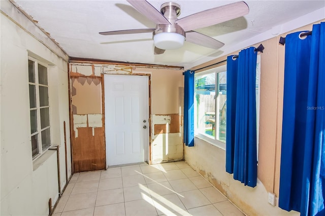 tiled spare room with ceiling fan