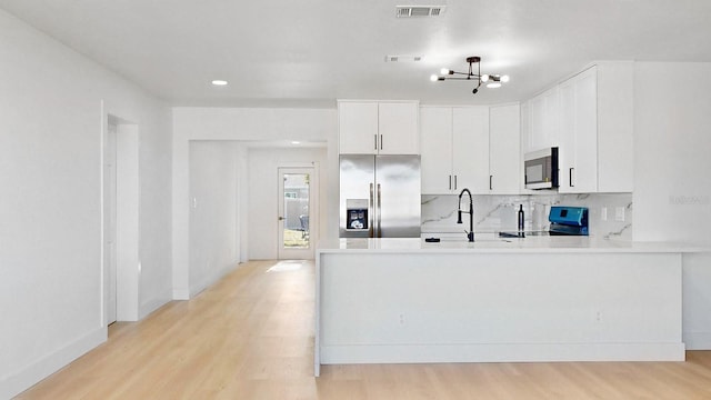 kitchen featuring white cabinets, light wood-type flooring, sink, and appliances with stainless steel finishes