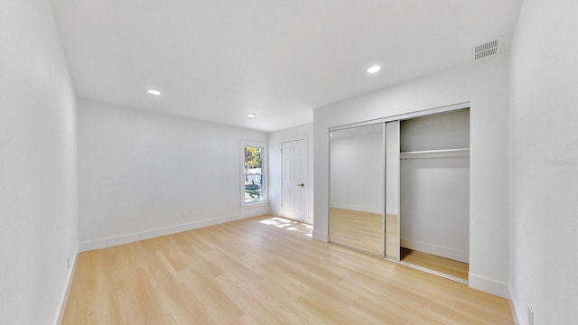 unfurnished bedroom with a closet and light wood-type flooring