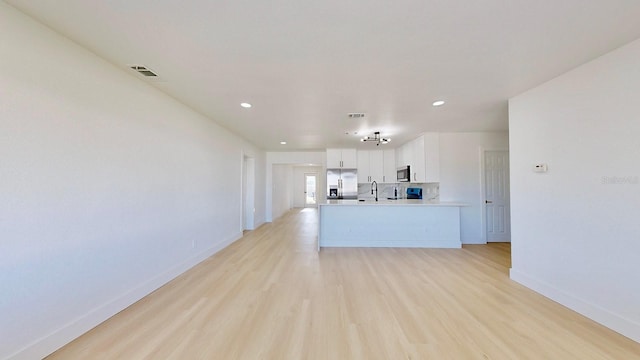 kitchen with white cabinetry, sink, stainless steel appliances, and light wood-type flooring