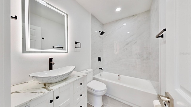 full bathroom featuring tile patterned flooring, vanity, toilet, and tiled shower / bath