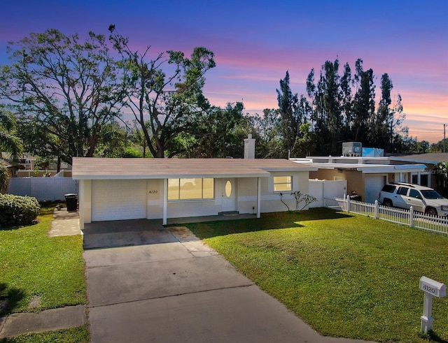 view of front of property with a garage and a yard