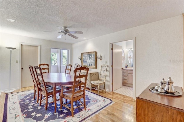 dining room featuring ceiling fan, a textured ceiling, and light wood-type flooring