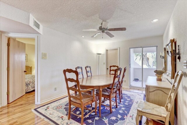 dining area featuring ceiling fan, a textured ceiling, and light wood-type flooring