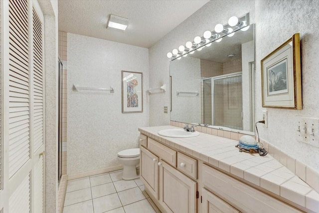 bathroom featuring vanity, a shower with door, tile patterned flooring, toilet, and a textured ceiling