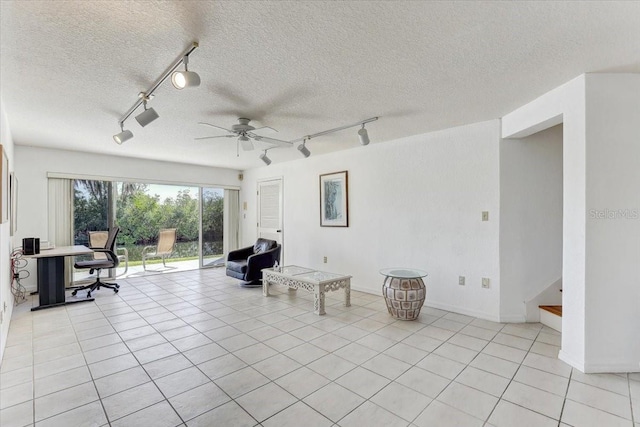 living area featuring ceiling fan, track lighting, light tile patterned flooring, and a textured ceiling