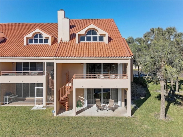 back of house with a yard, a balcony, and a patio area