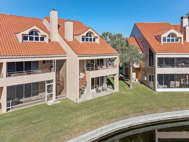 back of house featuring a lawn and a patio